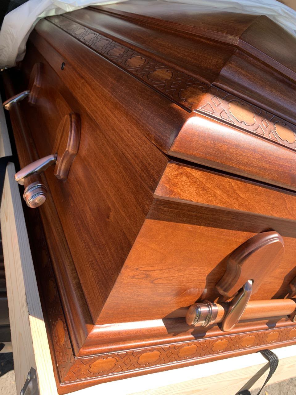 Detalle artesanal tallado a mano en el borde de un ataúd de Funerales VidaNueva