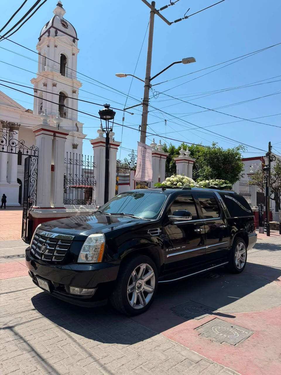 Unidad de traslado de Funerales VidaNueva frente a una iglesia, lista para brindar servicio inmediato